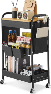 A black metal rolling cart with a wooden top, filled with various items like books, jars, a speaker, and a game controller.