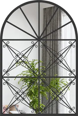 A decorative mirror with a window-like metal frame, reflecting a room with curtains and a plant.