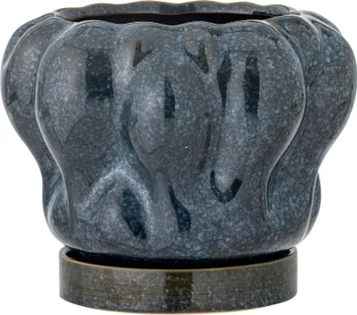 A dark blue ceramic planter with a textured, wavy design sits on a matching saucer.