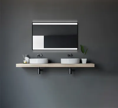 A modern bathroom vanity with a double sink and a lighted mirror.