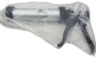 A caulking gun is wrapped in plastic.