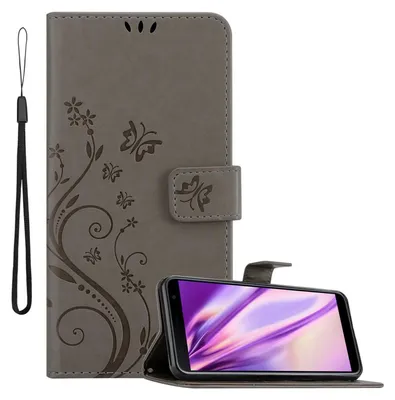 A gray flip phone case with a floral and butterfly design is shown open, with a smartphone inside. A wrist strap is attached to the case.