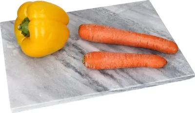 A yellow bell pepper and two carrots are placed on a marble cutting board.