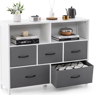 A white and gray dresser with fabric drawers and open shelves, decorated with household items.