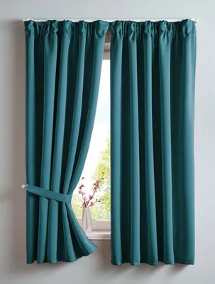 Two teal curtains are shown hanging in front of a window. One curtain is tied back with a fabric tie.