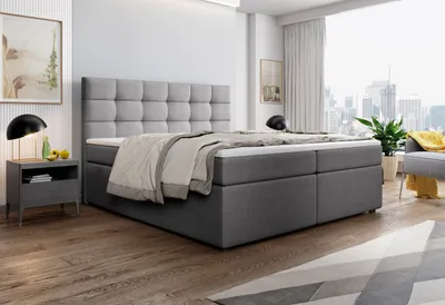 A bedroom scene with a bed, nightstand, and a window view of a city skyline.