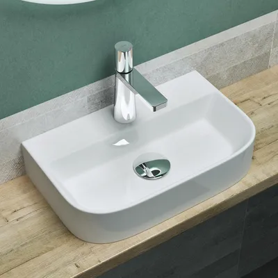 A white ceramic sink with a chrome faucet is shown on a wooden countertop.