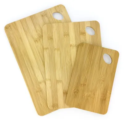 Three bamboo cutting boards of different sizes are arranged diagonally on a white background.