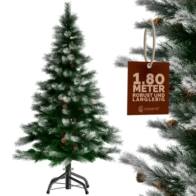 A full shot of an artificial Christmas tree with a tag attached to one of its branches.