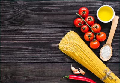 Produktbild von Wallario Fototapete Vliestapete, seidenmatte Oberfläche, einfache Verarbeitung, Größe 300 x 210 cm, Motiv Italienisches Menü mit Spaghetti, Tomaten, Salz und Chilischoten
