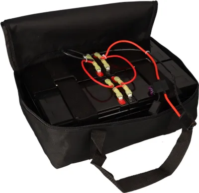 A black bag containing a set of batteries with red wires connected.
