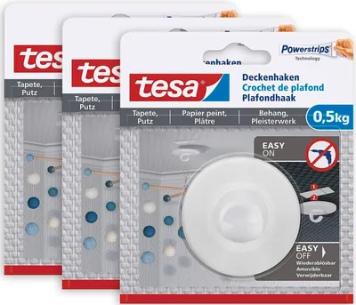 Three packages of tesa Deckenhaken (ceiling hooks) are shown, with one package prominently displayed in the foreground.