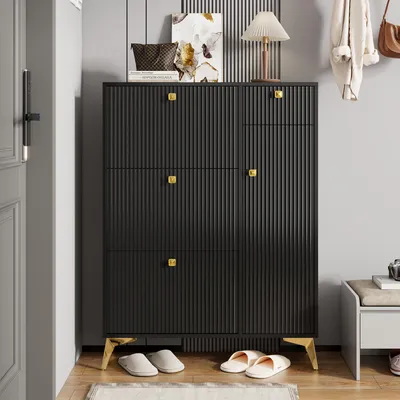 A black shoe cabinet with gold accents is shown in an entryway, with slippers on the floor in front of it.
