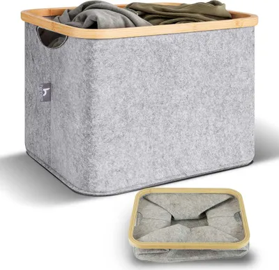 A light gray felt laundry basket with a bamboo rim is shown, filled with clothes. A smaller, folded version of the basket is displayed below it.
