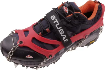 A single hiking shoe with red anti-slip crampons attached.