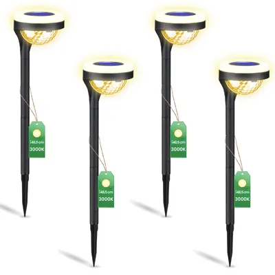 Four black solar garden lights with yellow light and blue solar panels, each with a green tag attached.