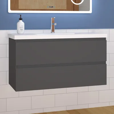 A wall-mounted bathroom vanity with a sink and faucet, set against a tiled wall and a mirror above.