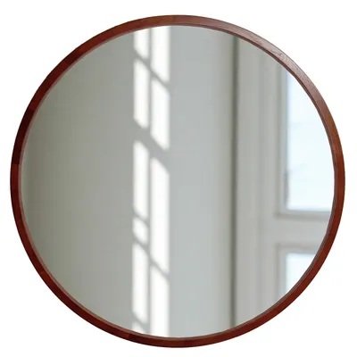 A round mirror with a wooden frame is shown against a white background with light reflections.
