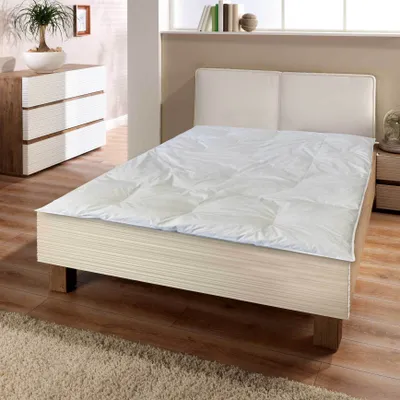 A bedroom scene with a bed and a dresser.