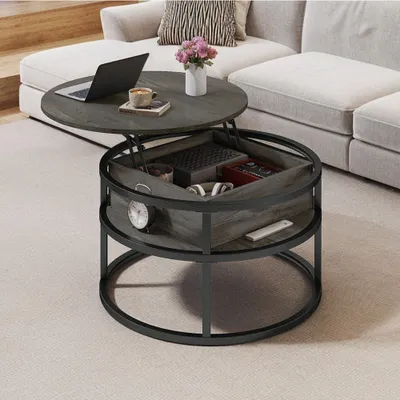 A round coffee table with a lift-top is shown in a living room setting next to a sofa.