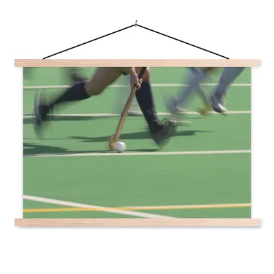 Produktbild von MuchoWow® Textilposter Ein Action-Foto von dribbelnden Eishockeyspielern 120x80 cm mit holzfarbenen Rahmen - Aufhängeset