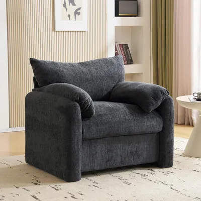 A dark gray armchair is shown in a well-lit room with a textured wall and a small side table.