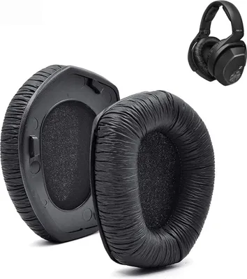 A close-up view of two black ear pads for headphones, with a pair of black headphones in the background.