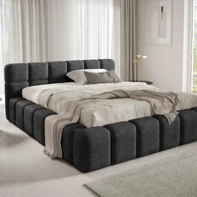 A modern bedroom with a large upholstered bed.