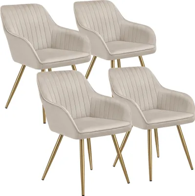 Four beige upholstered dining chairs with gold legs are arranged in a staggered formation against a white background.