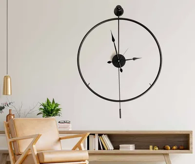 A modern living room with a large wall clock, a chair, and a console table.