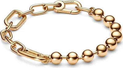 A close-up studio shot of a gold-colored bracelet on a white background.