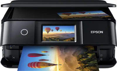 A black Epson Expression Photo XP-8700 Multifunction Printer is shown with a printed image of hot air balloons on the display screen and another printed image emerging from the paper output tray.