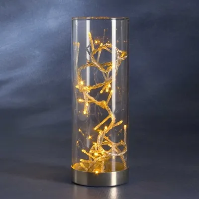 A glass cylinder filled with LED string lights.