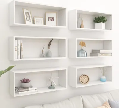 Six white cube shelves are mounted on a white wall, displaying various decorative items.