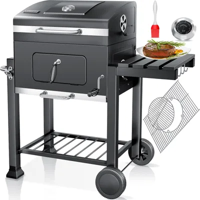 A charcoal grill with accessories and a cooked steak.