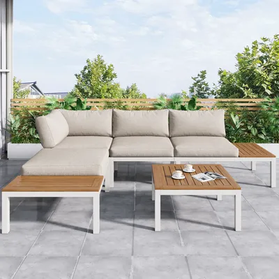 An outdoor patio with a sectional sofa and coffee tables.