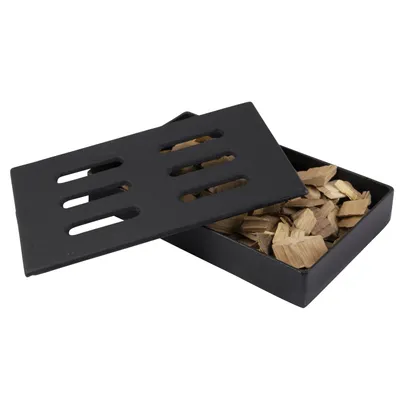 A black cast iron smoker box filled with wood chips, with its lid slightly ajar.