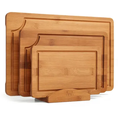 A set of three wooden cutting boards of varying sizes, stacked and displayed on a wooden stand.