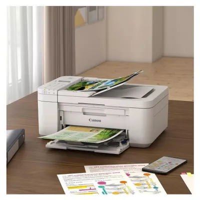 A Canon PIXMA TR 4751i Multifunktionsdrucker is shown on a wooden desk, printing documents and photos.