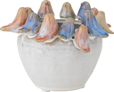 A ceramic pot decorated with small bird figures around the rim.