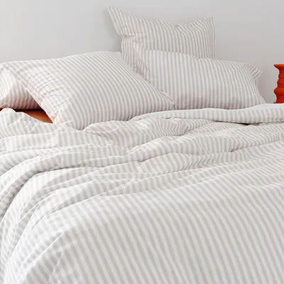 A neatly made bed with striped bedding.