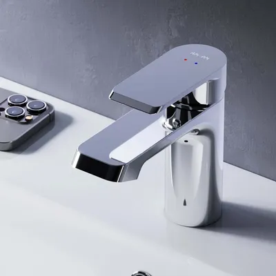 A modern chrome faucet sits on a white sink, with a smartphone in the background.