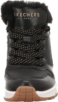 A close-up, front-facing view of a black Skechers boot with white polka dot laces and a white sole.
