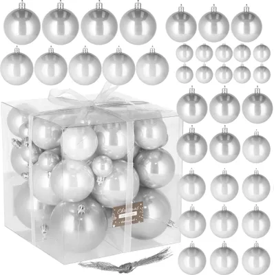 A collection of silver Christmas ornaments in a clear box, with additional ornaments arranged around it.