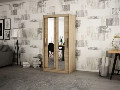 A modern bedroom with a wooden wardrobe with mirrored doors, a sofa, and a floor lamp.