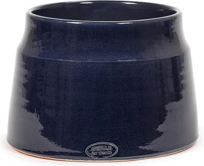 A dark blue ceramic pot with a textured finish sits on a white surface.