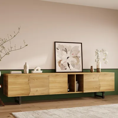 A modern wooden TV stand with a curved front and black metal legs, placed in a room with pink and green walls.