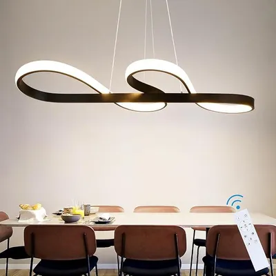 A modern LED pendant light fixture hangs above a dining table set with chairs and place settings.