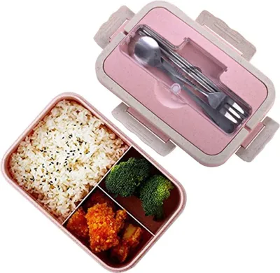 A pink and beige bento box with food and cutlery.