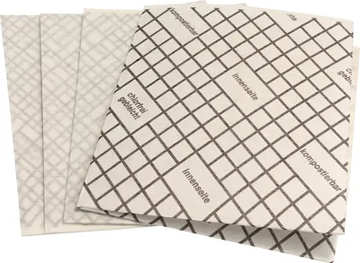 A stack of compostable filter sheets with a grid pattern and German text.